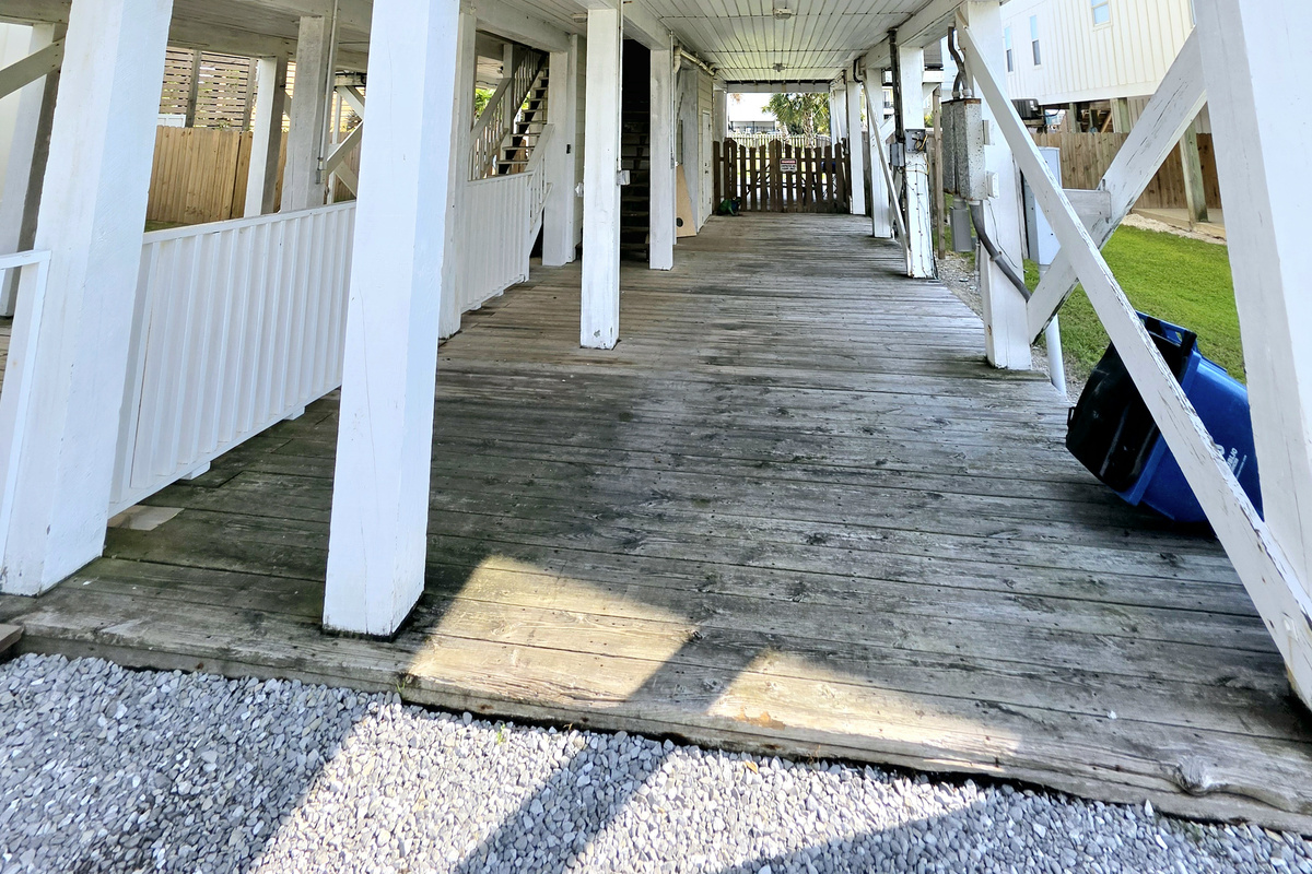 Shaded under-house deck with stairs to the unit