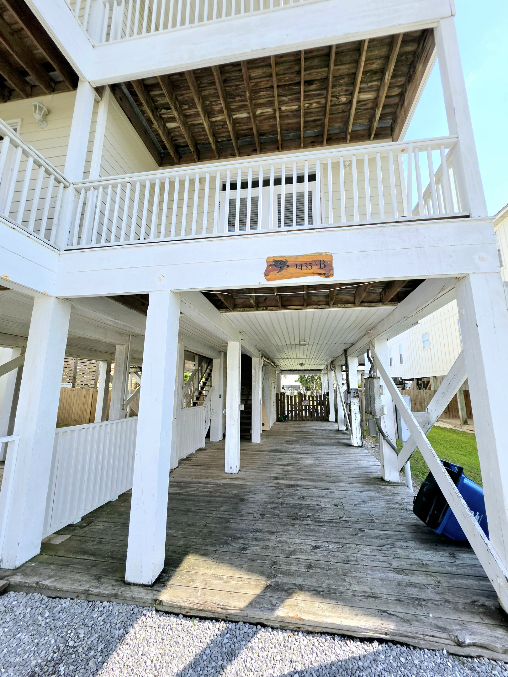 Shaded under-house deck with stairs to the unit