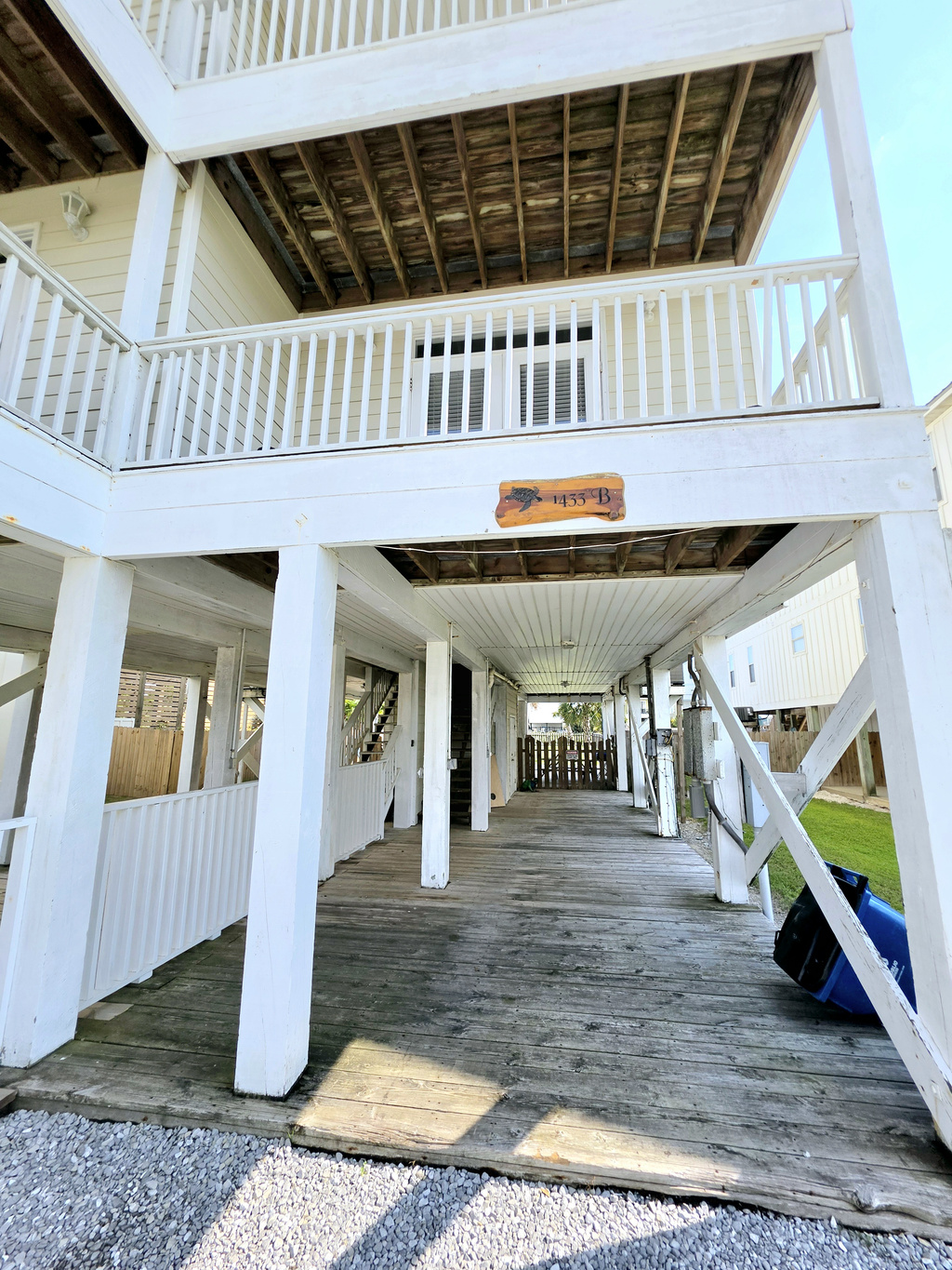 Shaded under-house deck with stairs to the unit
