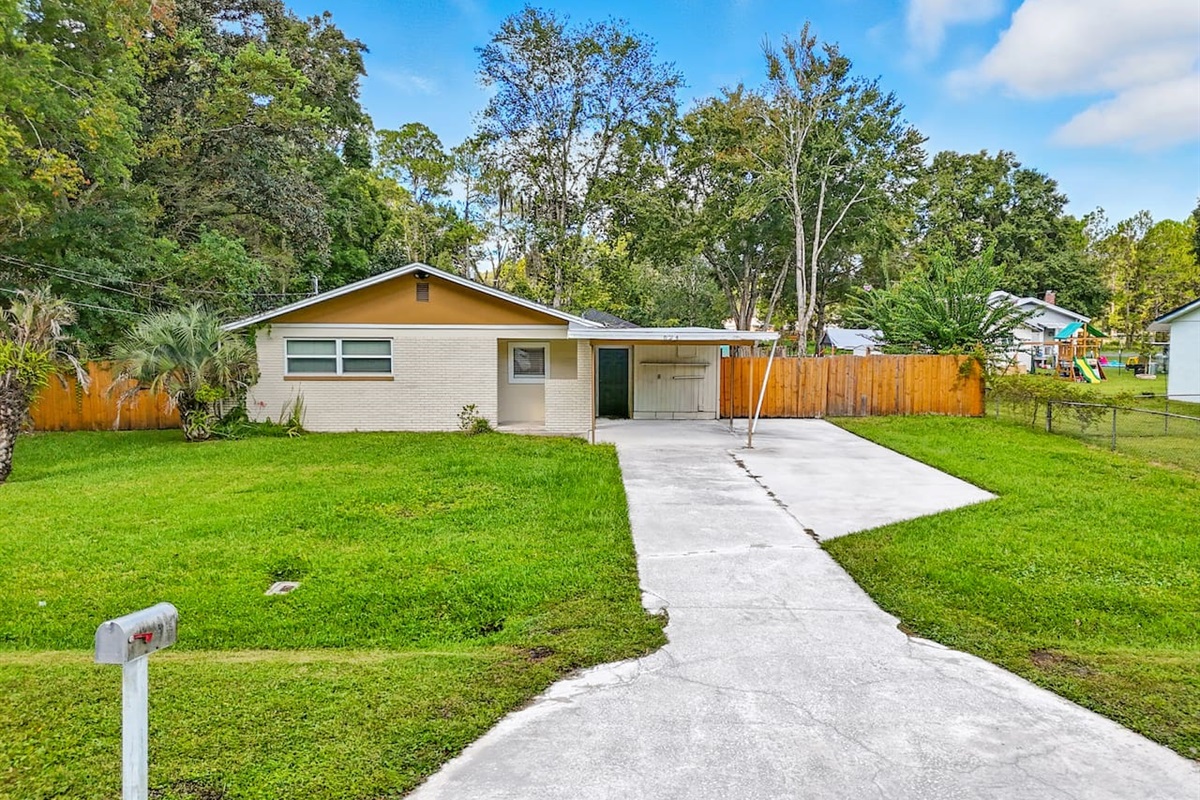 Front view of the home with large driveway, and plenty of parking