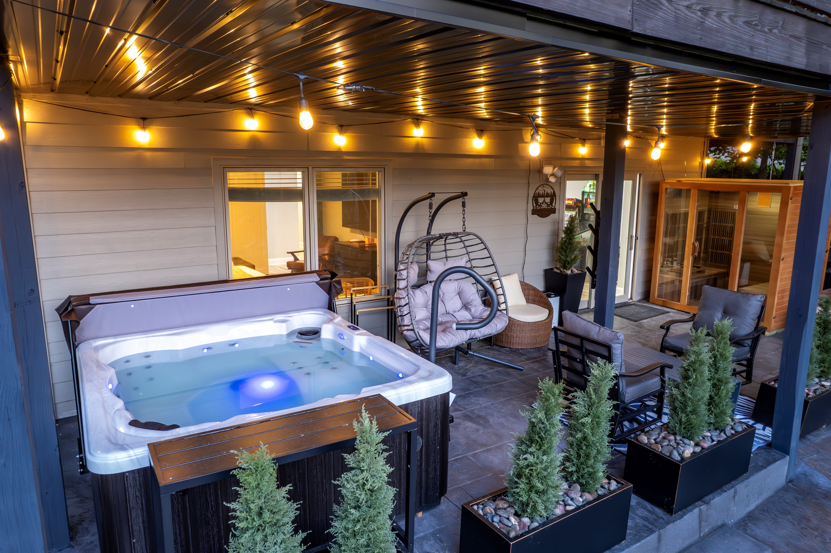 Luxury meets comfort: enjoy a 6-person hot tub, dual papasan chairs & plush seating on a stylish stamped concrete patio. Covered for year-round relaxation in any weather