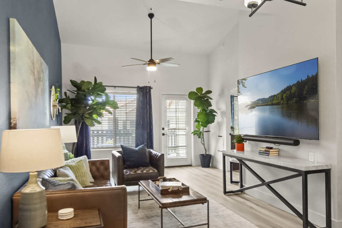 Bright living room with a large TV, comfortable seating, and an inviting layout perfect for relaxing after a day out.