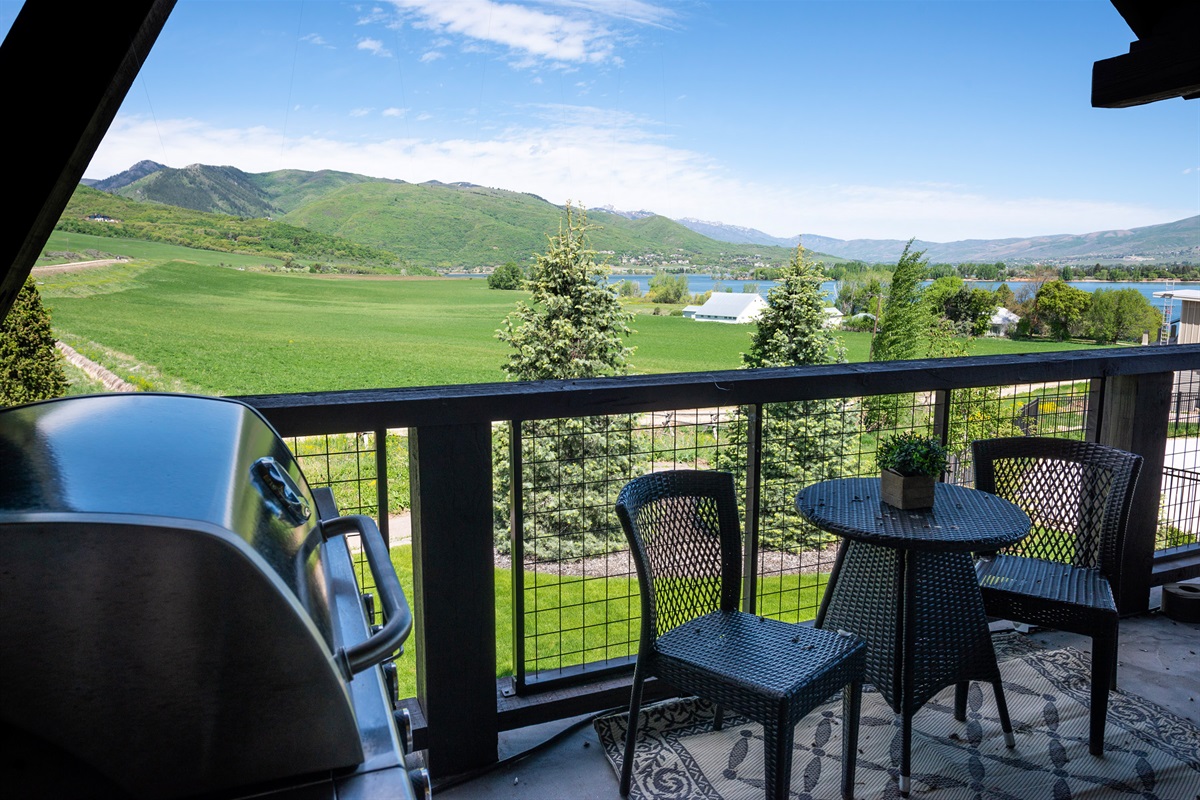 An elevated outdoor deck complete with grill and lounge seating, where sweeping landscapes provide a breathtaking backdrop for relaxation and entertaining.