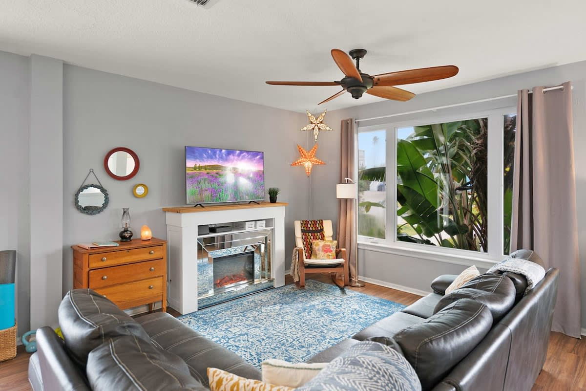 The living room has a proper fireplace and a cable TV above it, with a sectional deep enough for the whole family. This is the room everybody drifts back to once the sun has finally gone down over the pool.