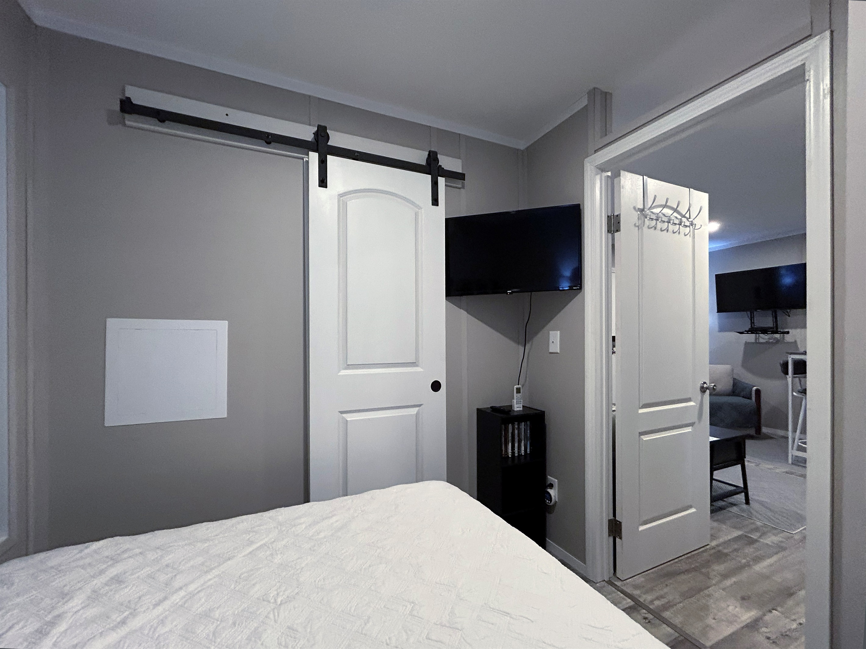 Bedroom #1 with queen bed, smart tv, en suite bathroom and hidden washer/dryer combo in closet