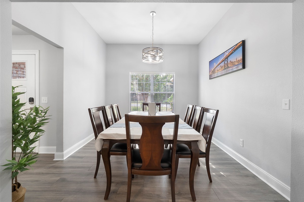 Gather around this beautifully set dining table for meals, games, or conversation. The room is bright and airy, thanks to the large window and neutral tones, while the seating for eight makes it perfect for group dinners or family feasts.