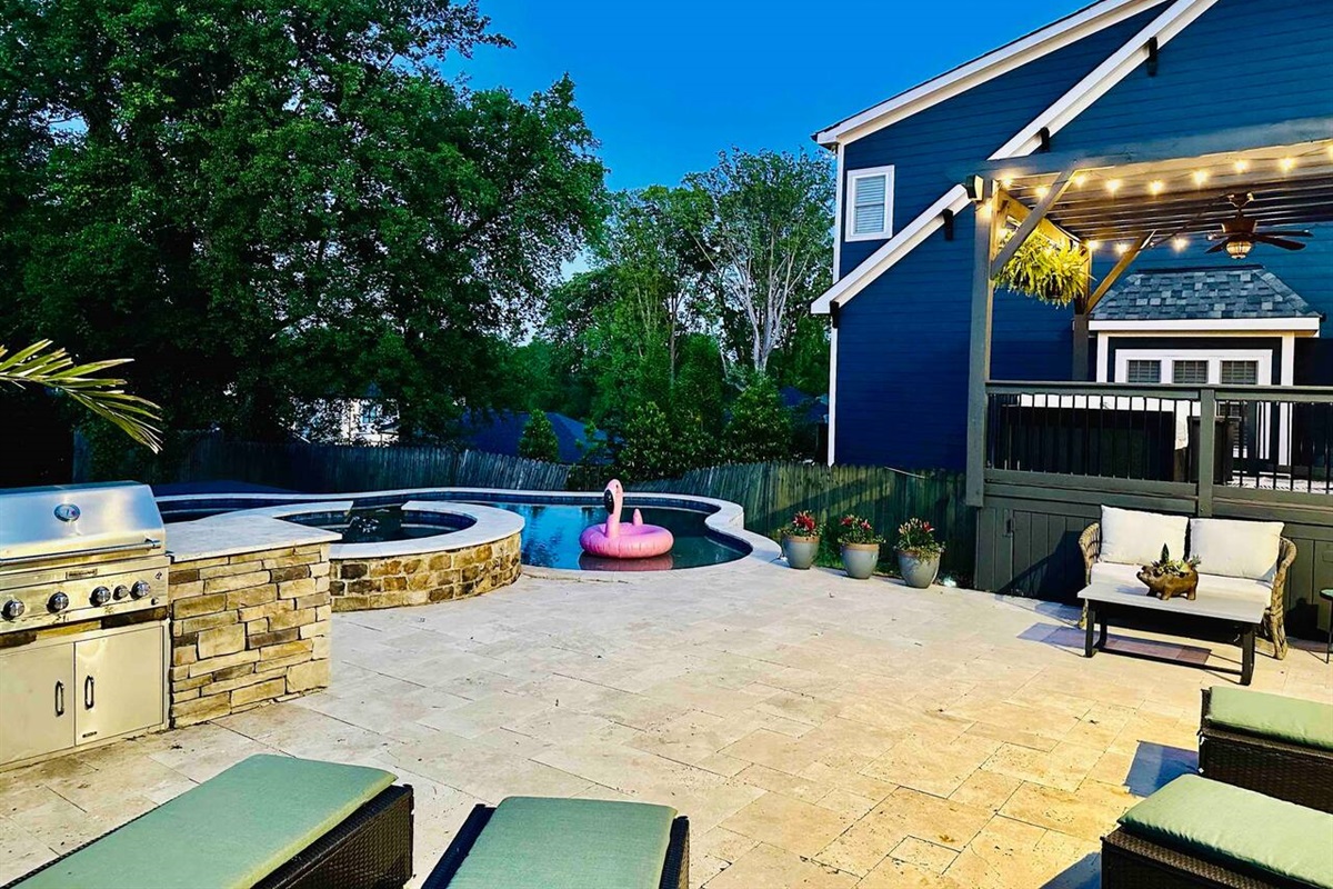 The backyard has a grill, sun loungers, and seating areas overlooking the pool and hot tub.