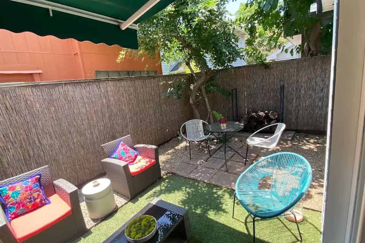 Backyard with patio seating and kid-friendly play space.