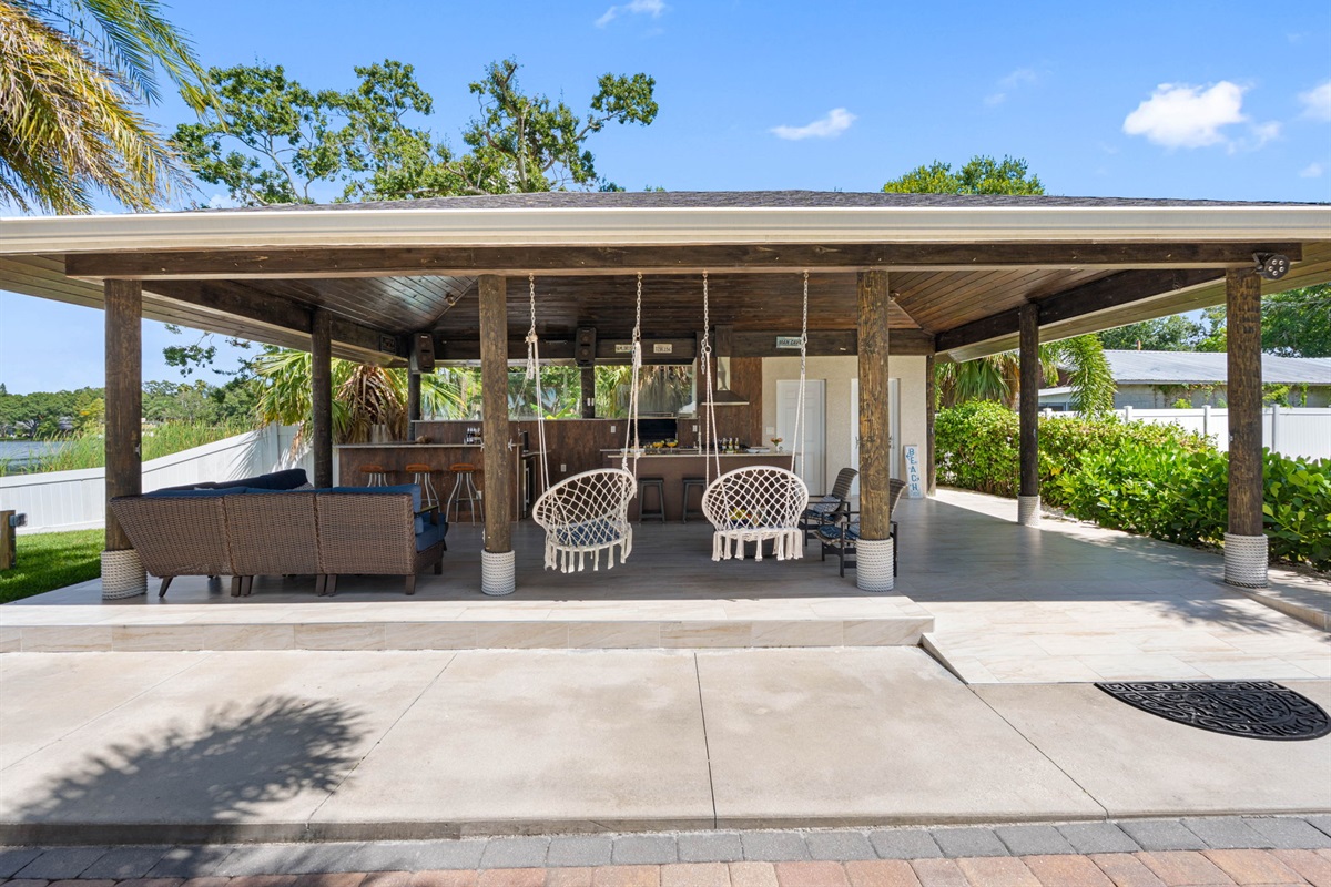 The patio flows seamlessly into the lush green yard and waterfront, creating a resort-style atmosphere right at home.