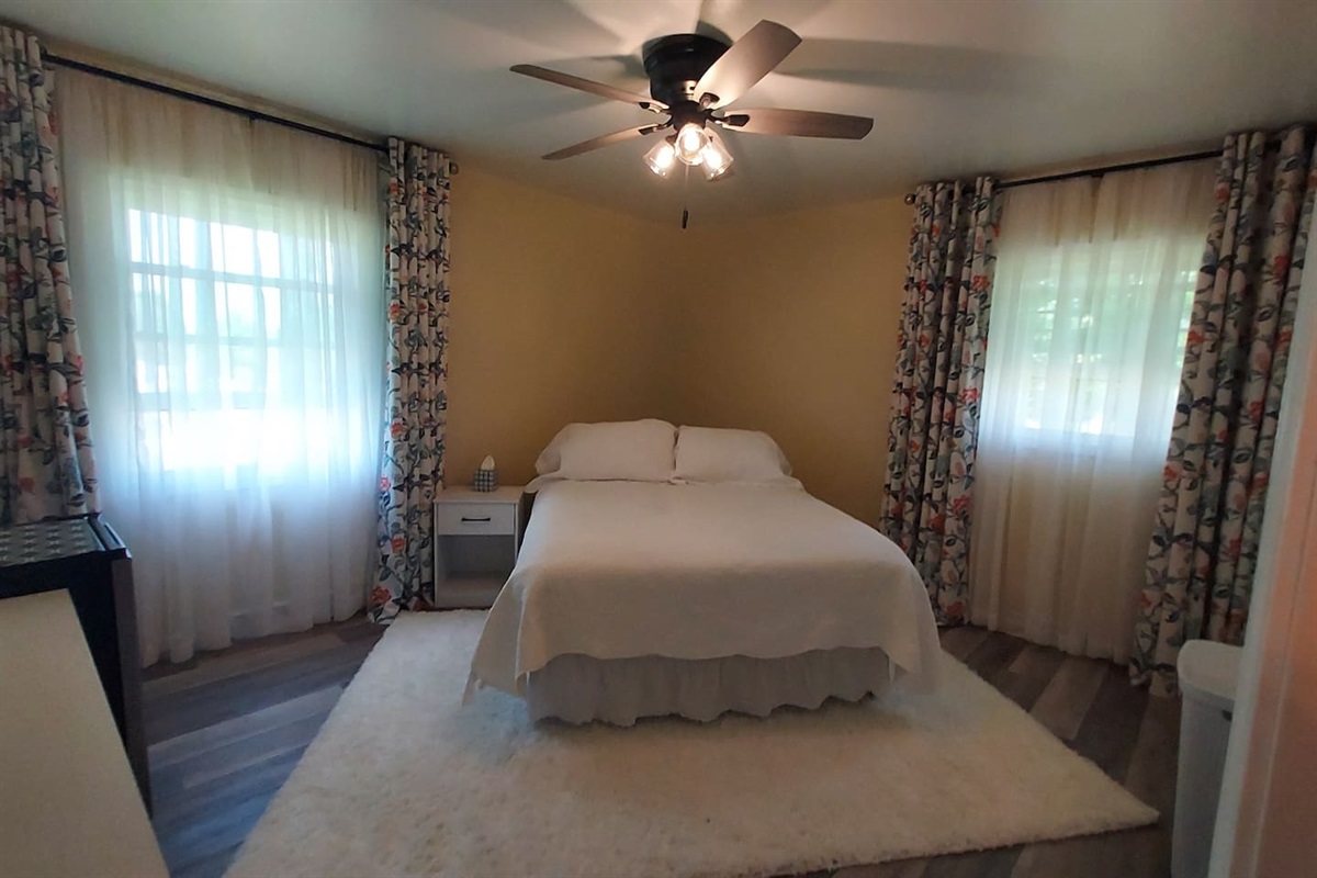 This room has a queen bed with a comfy 12" cooling foam mattress & a dresser. Guests love the peaceful half-acre backyard view. And yes—there’s a sleek black urinal in the private bathroom, a playful nod to comfort and style.