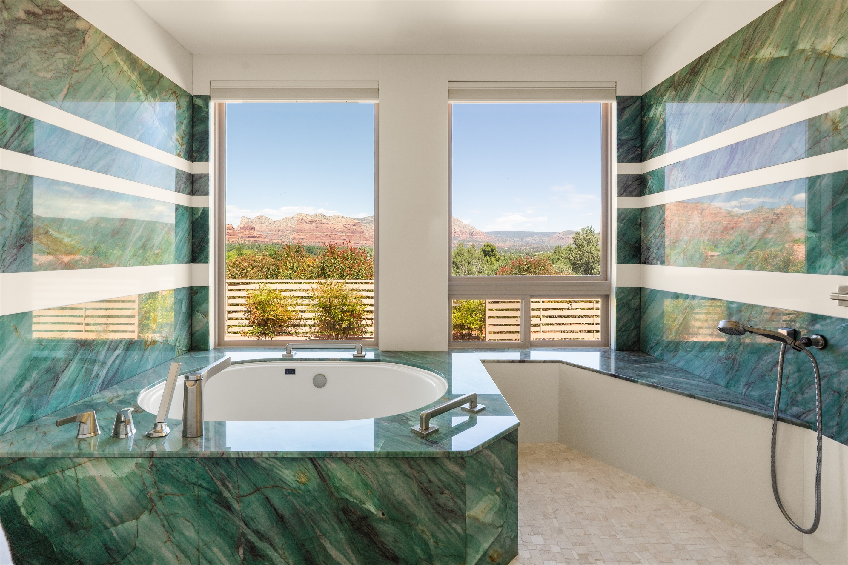 Soak in pure luxury. Our primary en-suite features a massive custom green marble soaking tub with unobstructed, panoramic views of the Sedona red rocks.