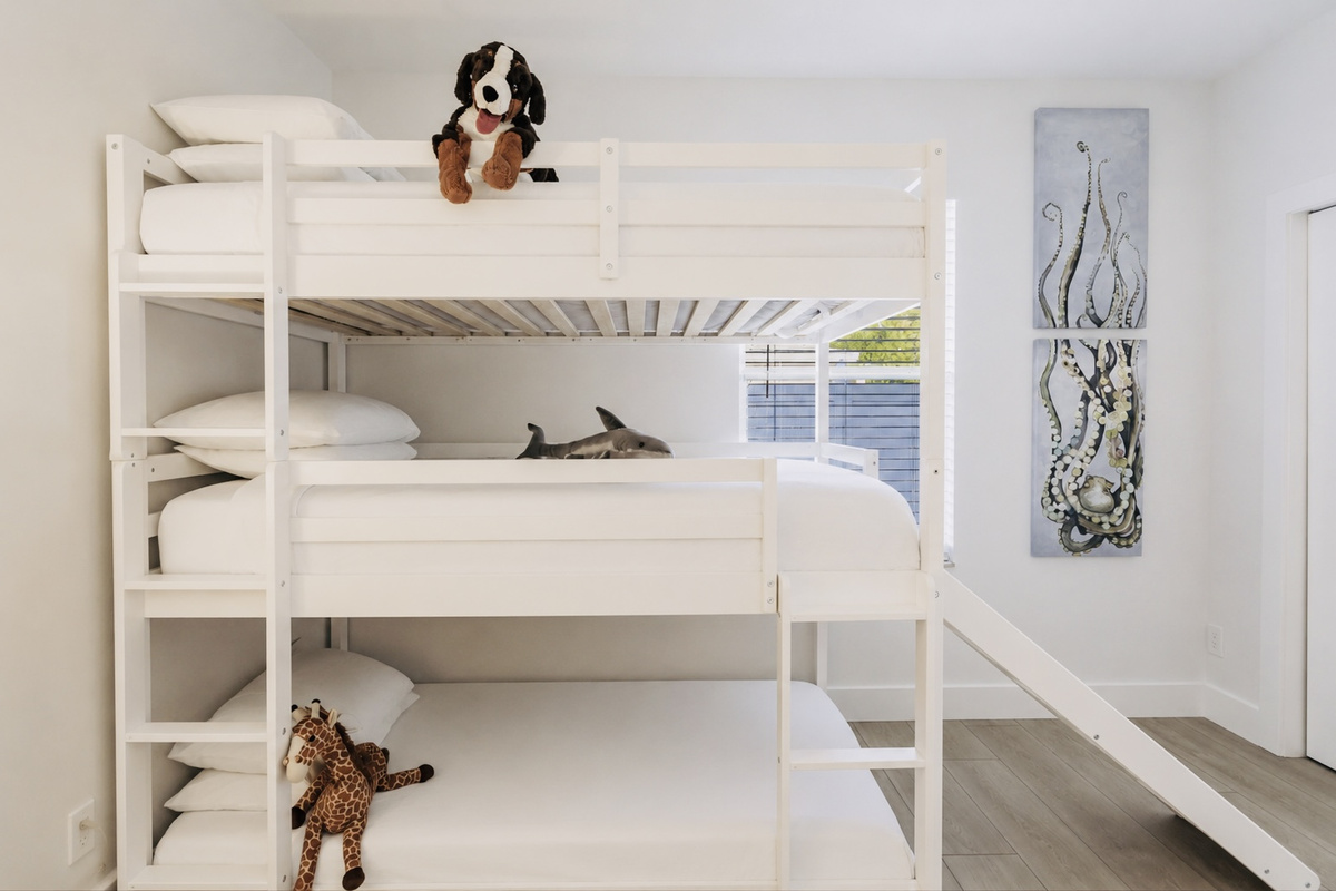 Triple bunk beds with a slide and a queen bed