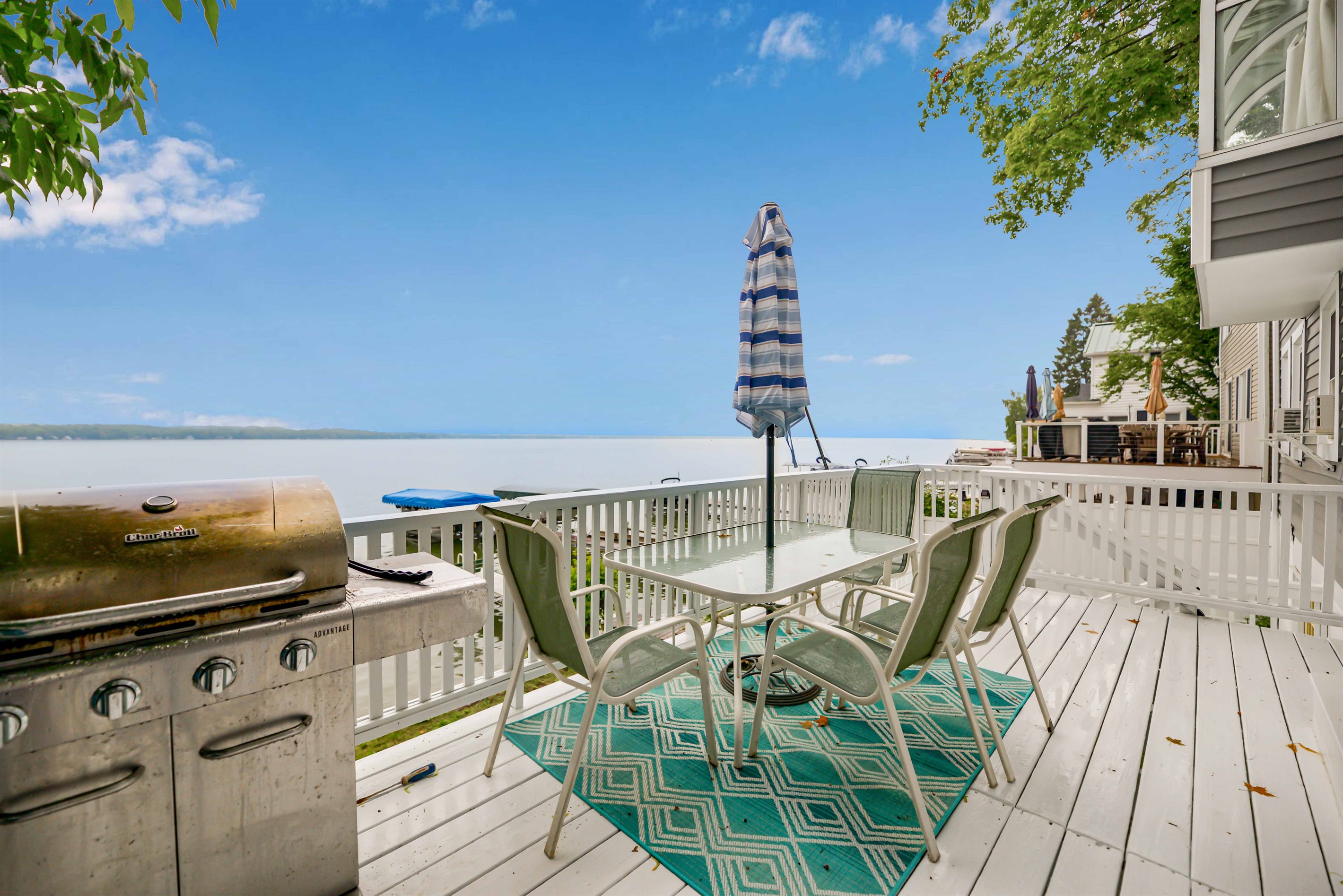 Outdoor dining and grill area overlooking the water, ideal for summer meals