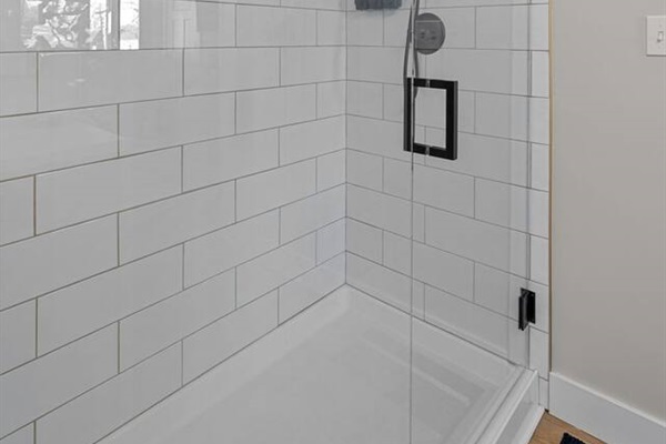 Spacious shower stocked with Shower gel, Shampoo, and Conditioner.