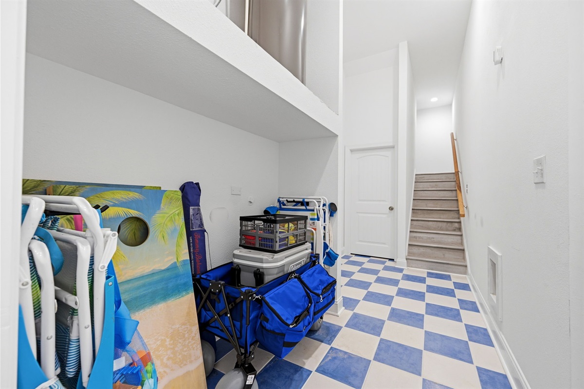 Convenient ground-level storage area stocked with beach gear, chairs, games, and a wagon for guest use