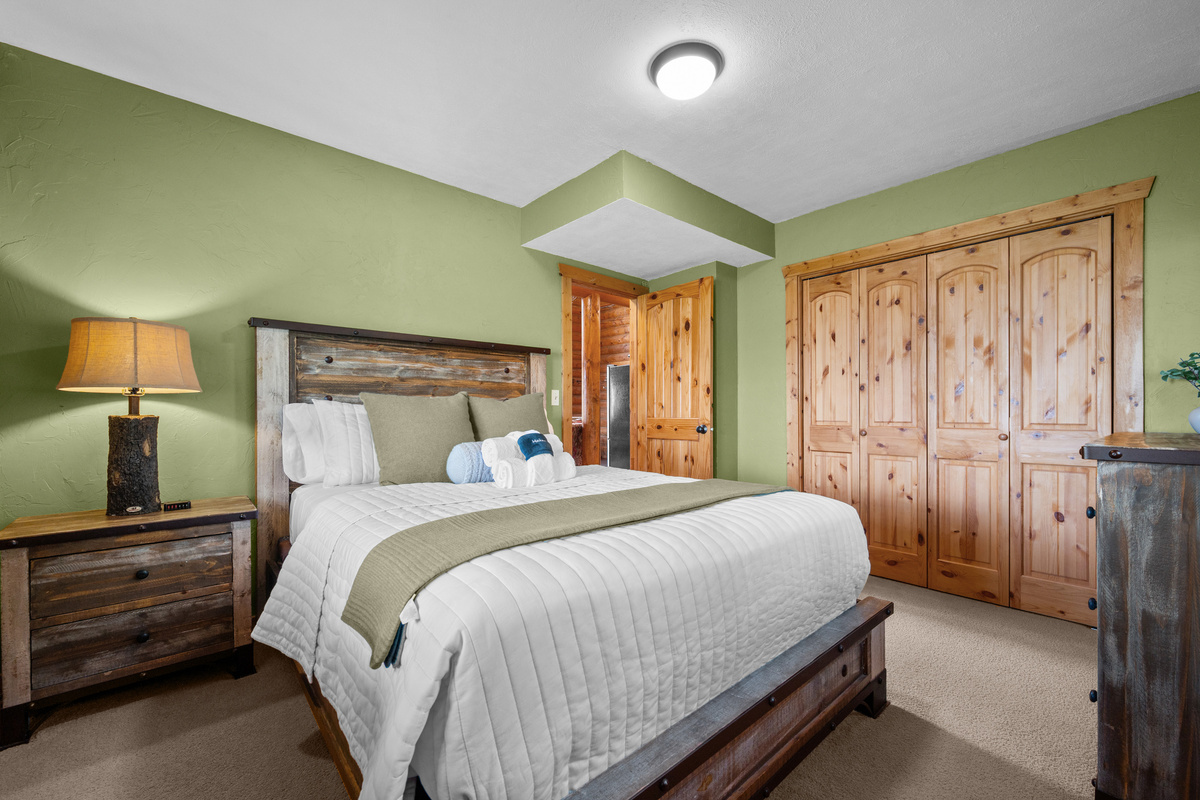 Queen bedroom with rustic furnishings, generous closet space, and a peaceful retreat feel.