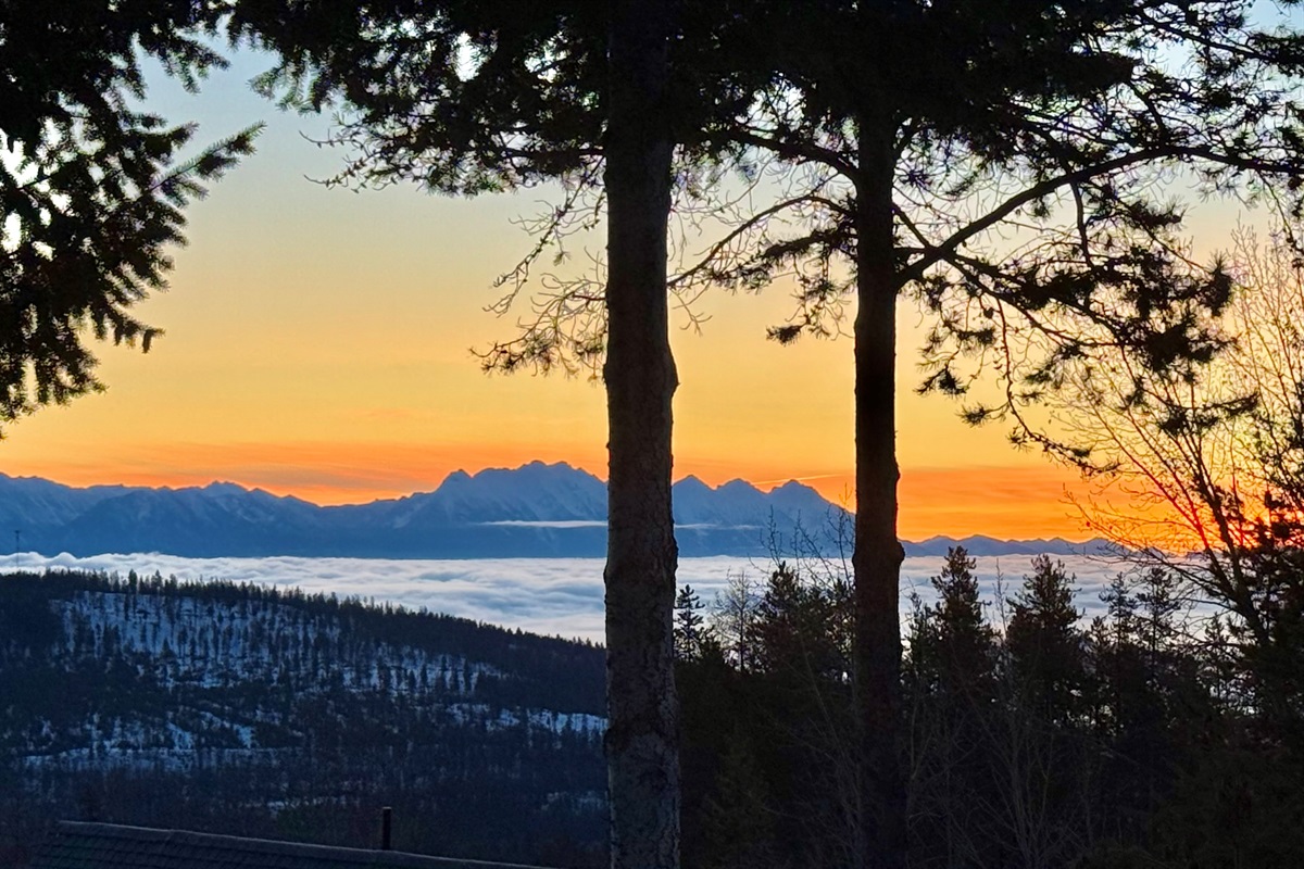 Mountain Panorama: A breathtaking east-facing view from the private deck overlooking the Rocky Mountain range during a golden sunrise.