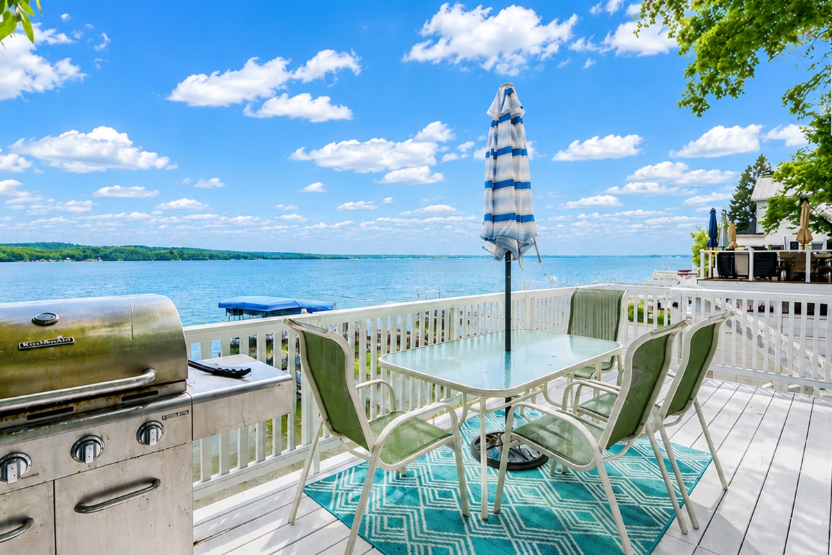 Outdoor dining and grill area overlooking the water, ideal for summer meals