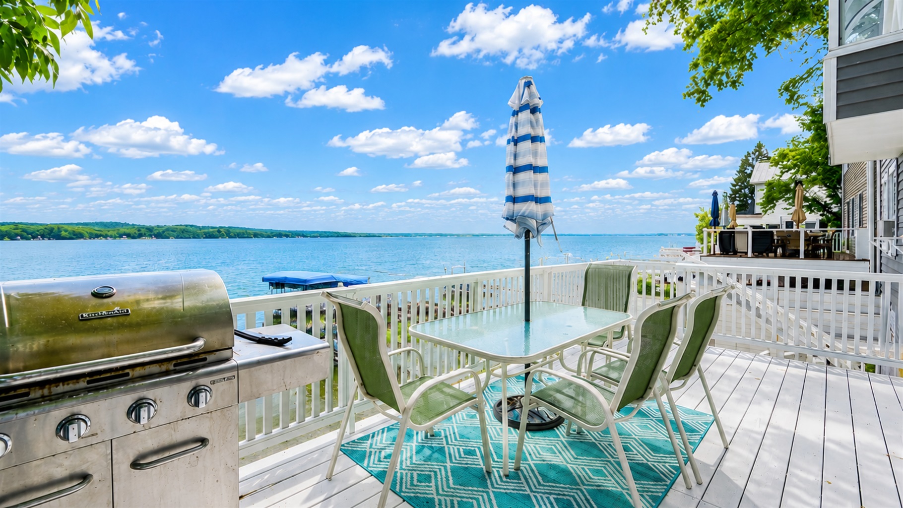 Outdoor dining and grill area overlooking the water, ideal for summer meals