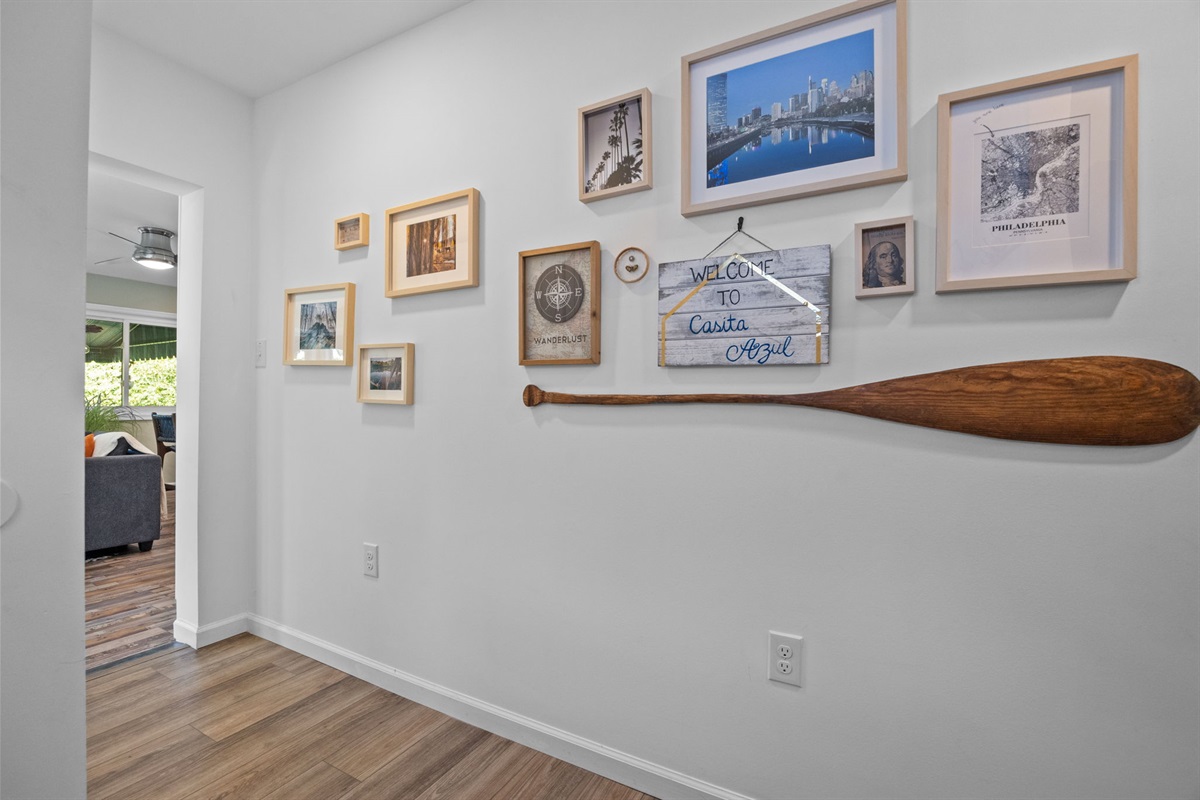 Accent wall showcasing a curated mix of images and a rustic paddle for a unique touch.