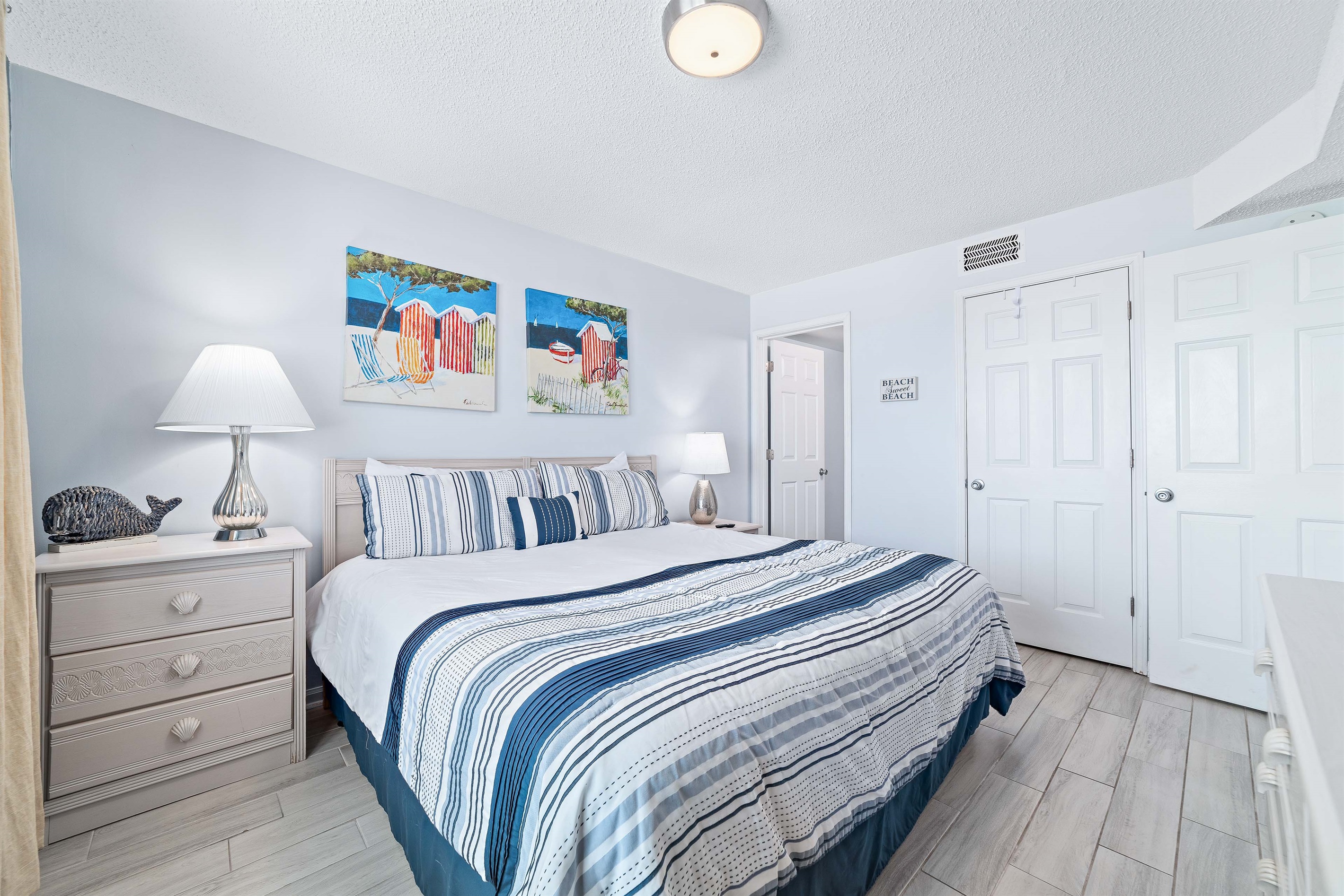 This charming Primary bedroom offers a comfortable bed with vibrant linens, complemented by practical storage solutions. A delightful space to unwind.