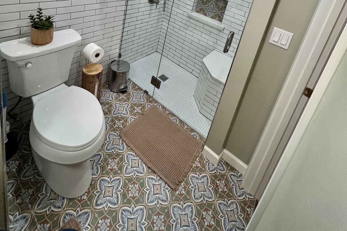 Refresh in your private, spa-like bathroom, featuring a modern walk-in shower and designer tile.