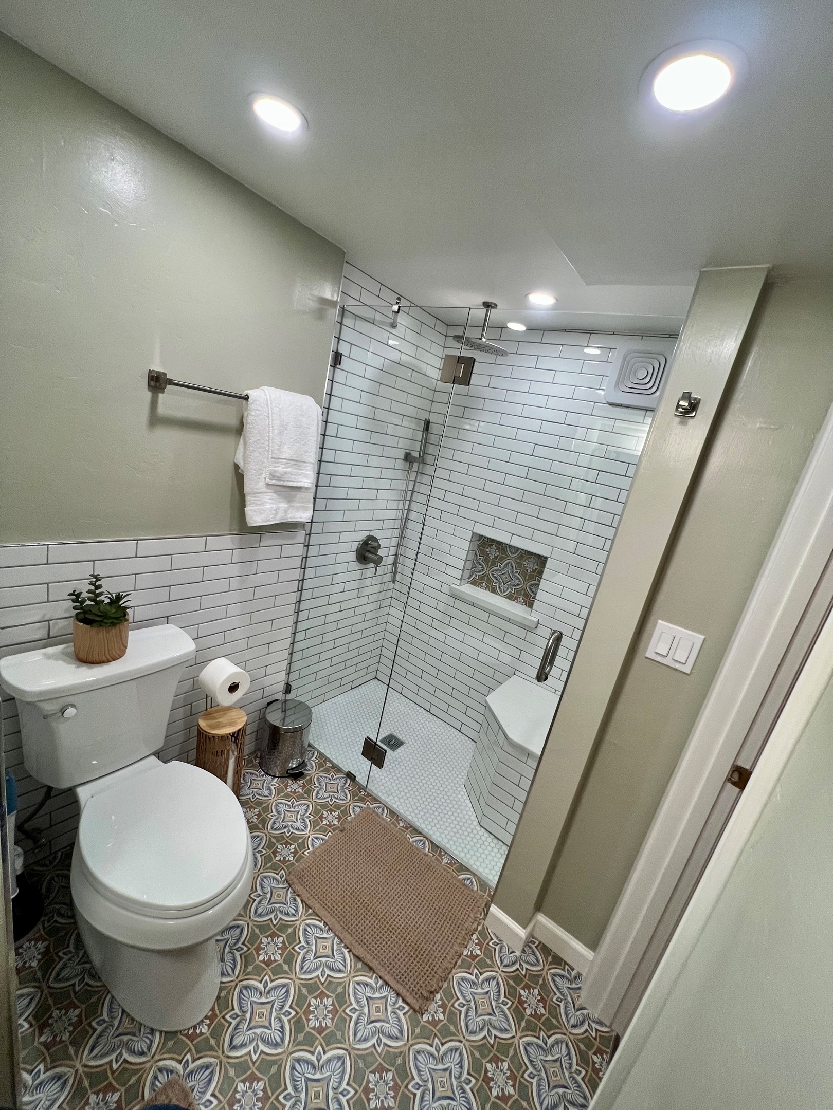 Refresh in your private, spa-like bathroom, featuring a modern walk-in shower and designer tile.