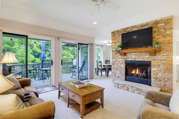 Gather around the stone fireplace after a day on the mountain, with a large-screen TV above and the deck just steps away.
