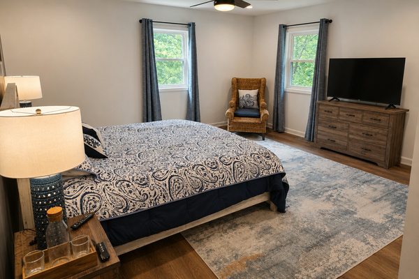 Main-floor primary bedroom with a king bed, cozy lighting and a calm, comfortable layout.