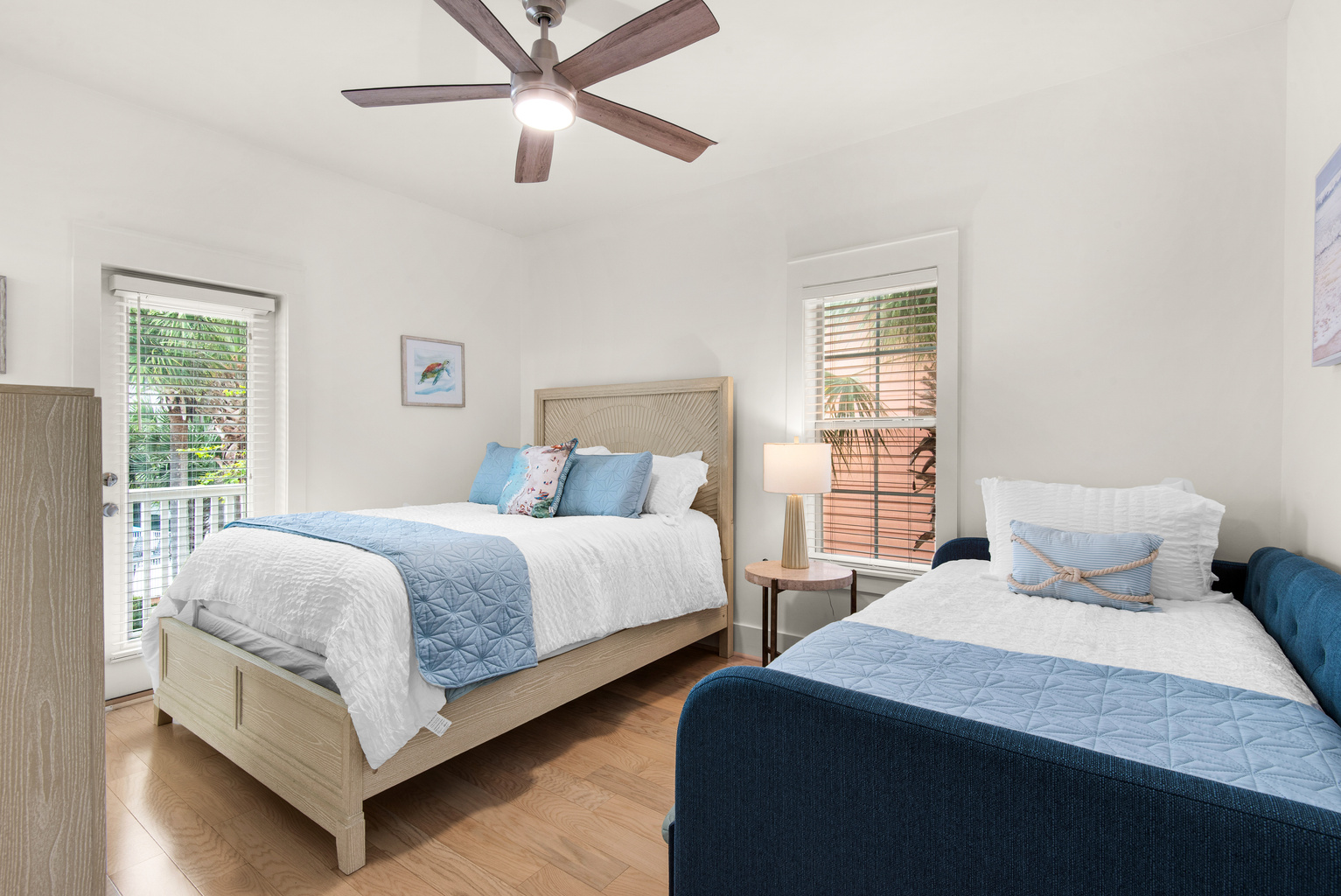 Second bedroom at Seagrove Bungalow 103 with two separate beds, bedside lighting and a ceiling fan.