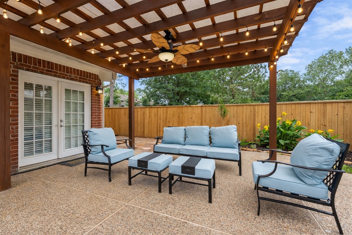 Relax under the covered pergola with cozy cushioned seating and ambient café lights — the perfect shaded spot for morning coffee or evening wine.