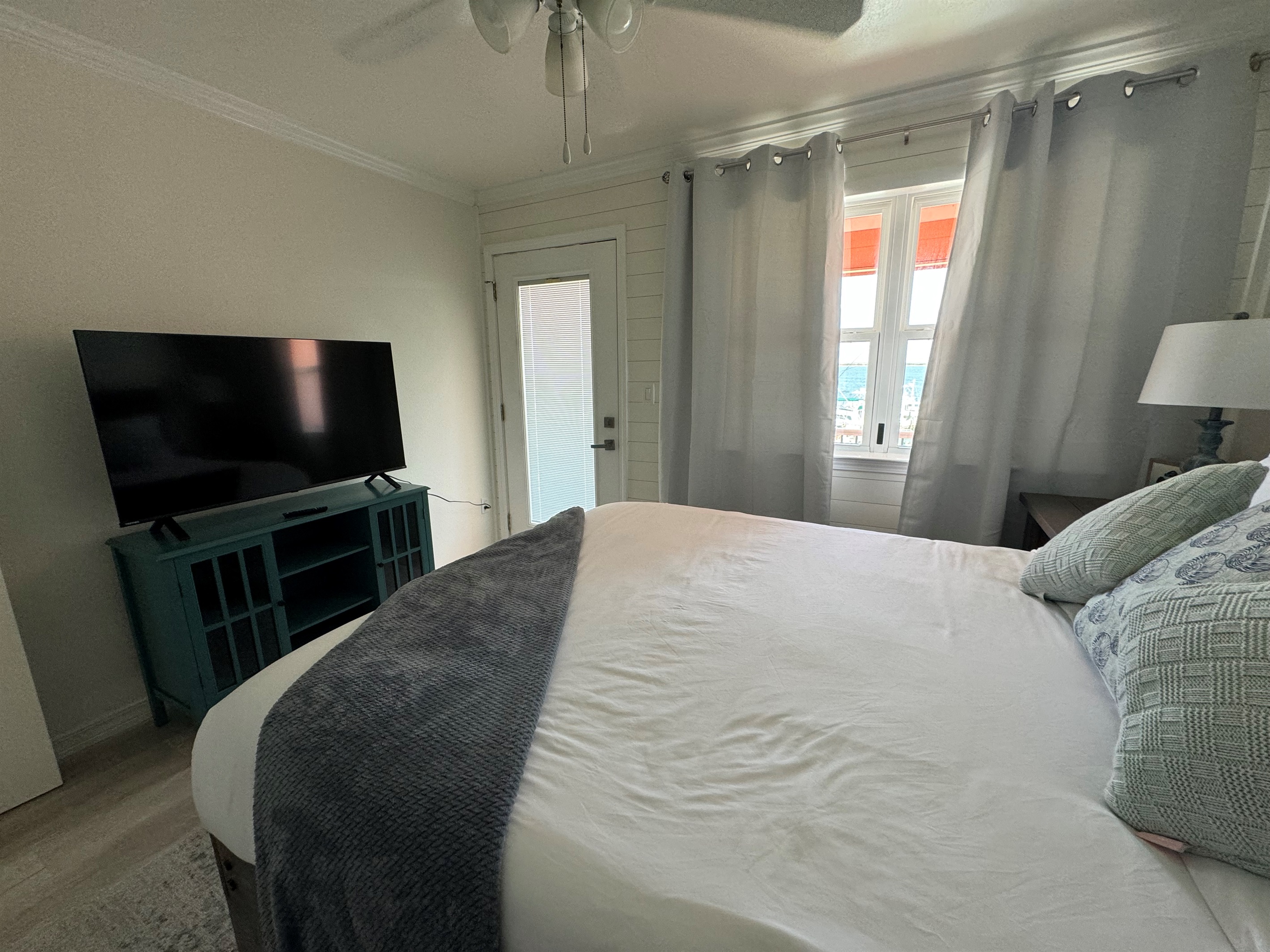 Second bedroom with queen bed and smart tv, balcony access