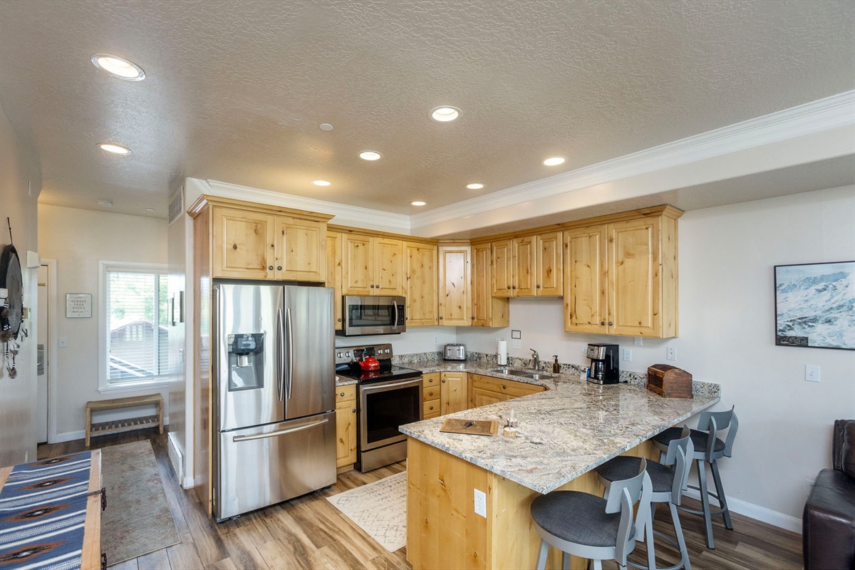 Cook in style in this well-equipped chef inspired kitchen featuring granite countertops, modern appliances, and plenty of space for preparing meals.