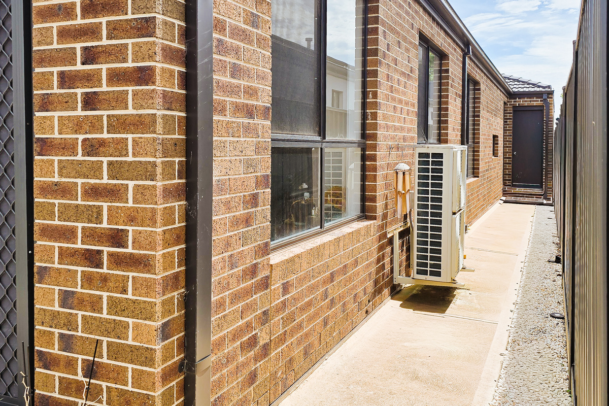 Move easily around the side of the home with a paved walkway, fenced boundary and direct connection toward the rear outdoor space.