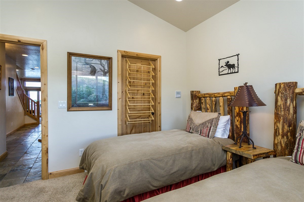 Another inviting bedroom with rustic lodge-style furnishings and soft natural light, designed for comfort and restful nights.