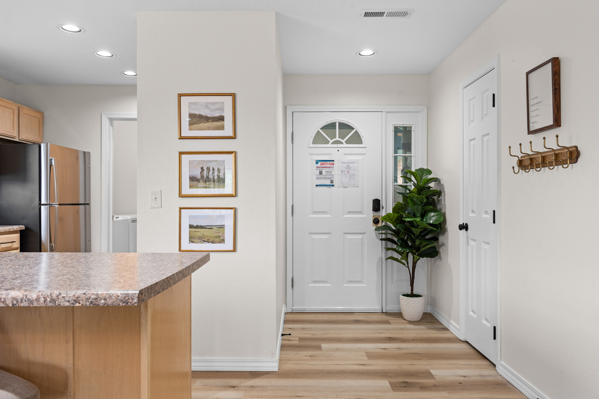 Enter beside the guest bedroom and bathroom, with the kitchen and main living areas just beyond.