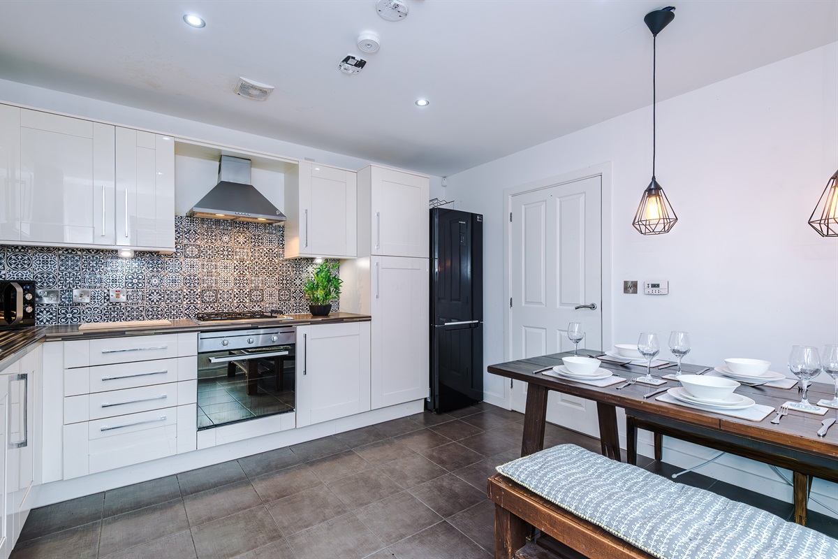 The bright and spacious kitchen benefits from a large dining table and cushioned benches
