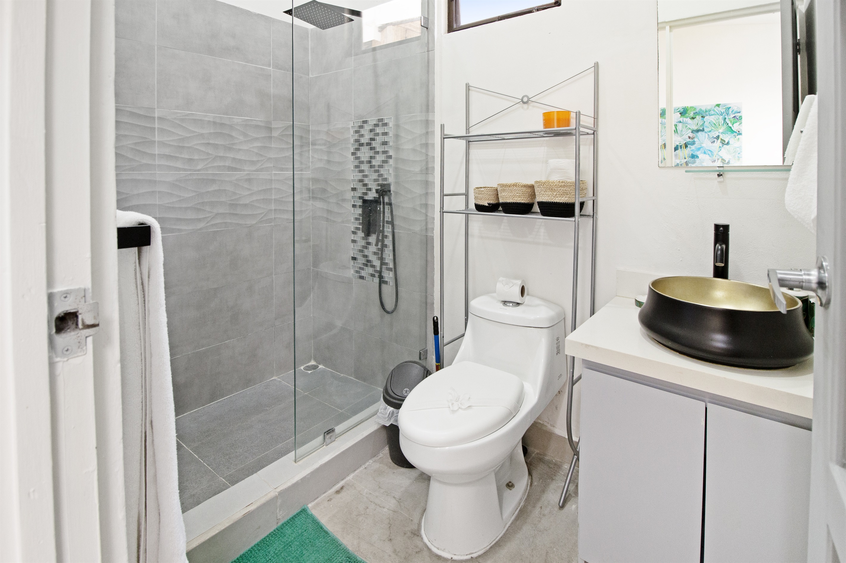The second bathroom has a tiled walk-in rain shower and copper sink