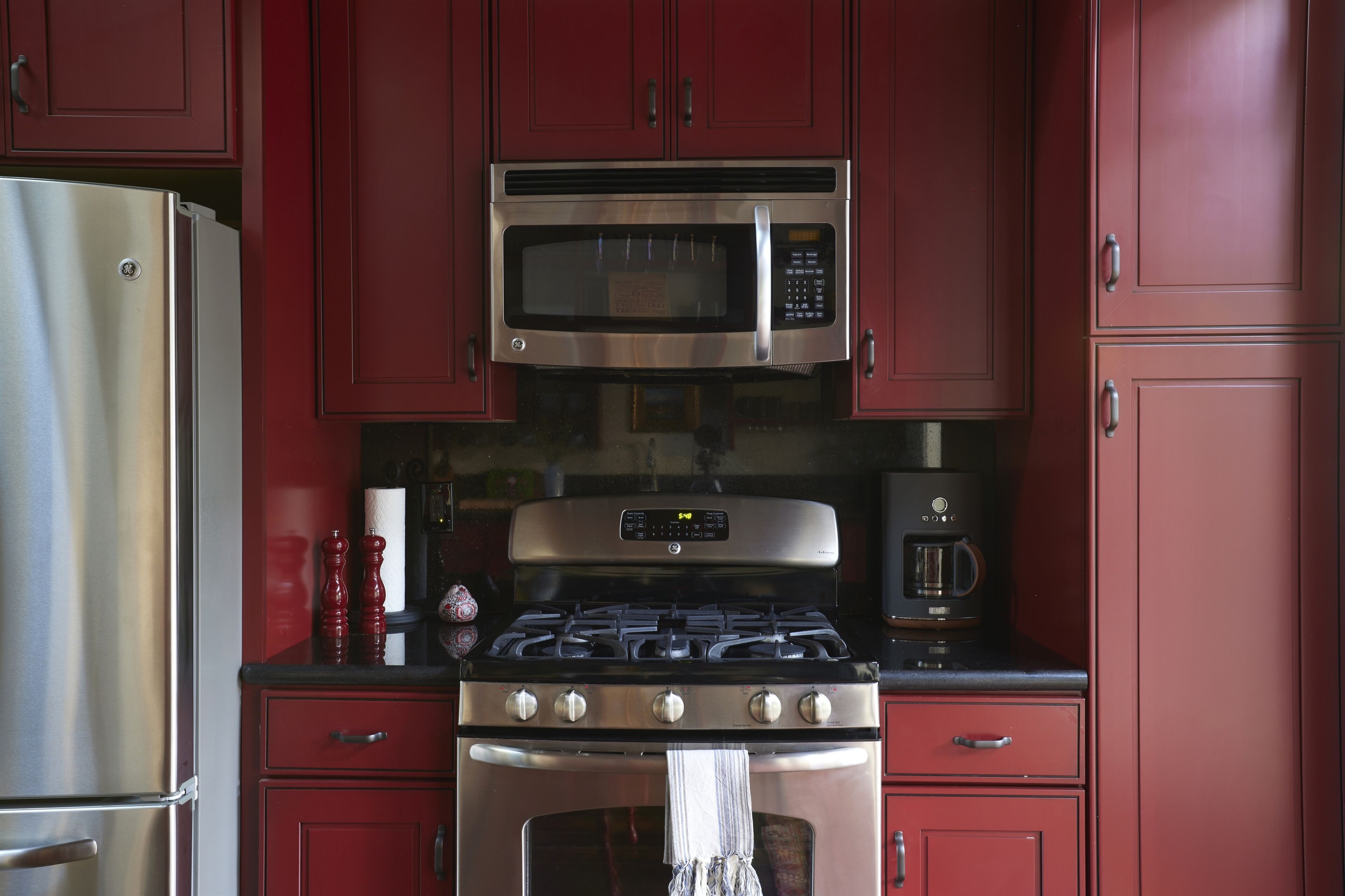 Range, oven, microwave, fridge, and coffee maker.
