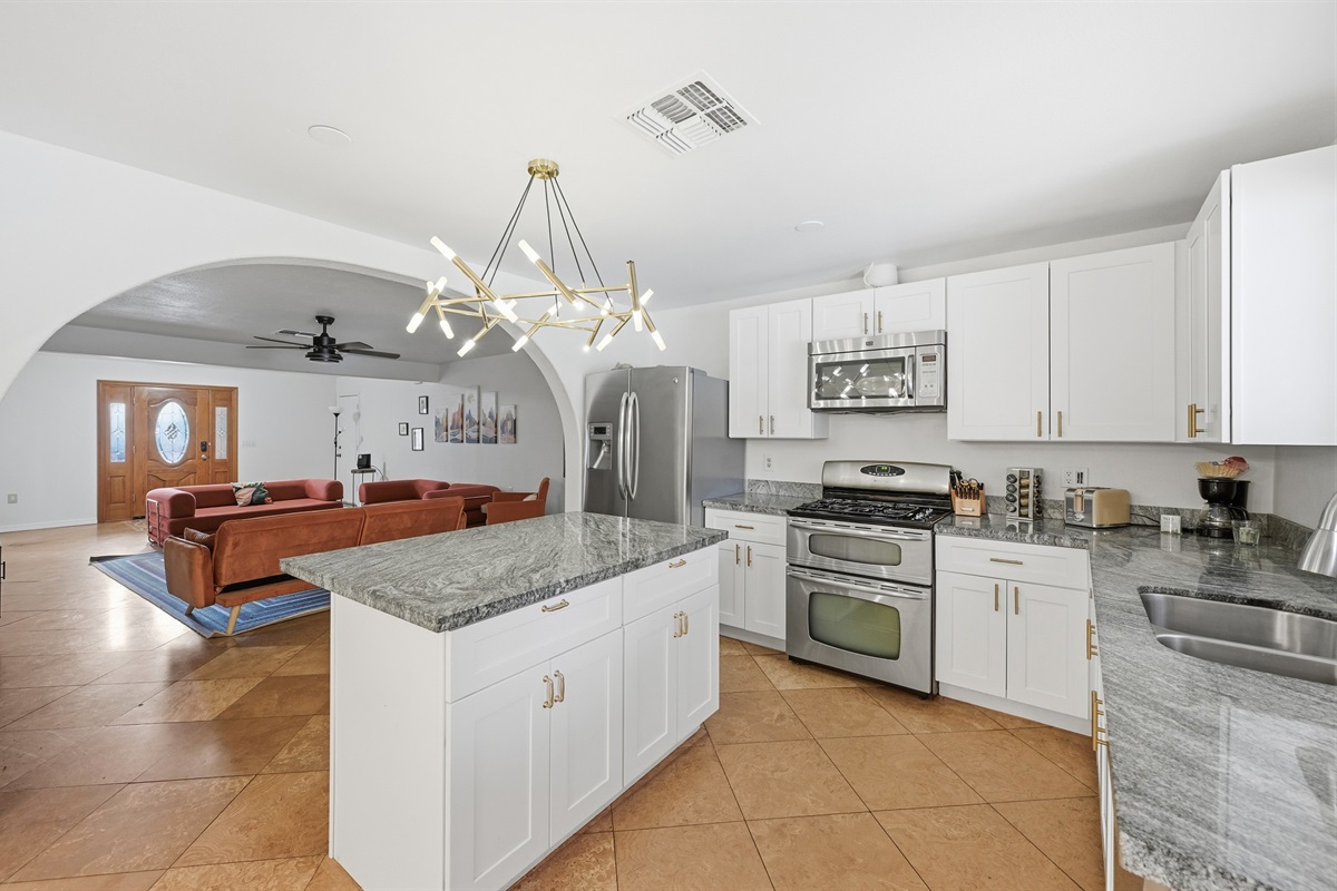This modern kitchen features stainless steel appliances, sleek granite countertops, and a central island perfect for morning coffee or evening cocktails.