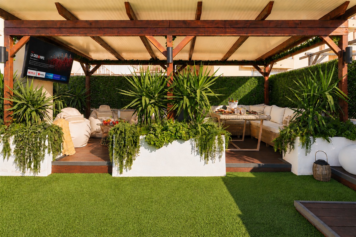 Relax beneath the covered pergola with cozy seating, fireplace, and dining area. Perfect for long evenings, romantic dinners, or movie nights on the outdoor TV under soft ambient lights.