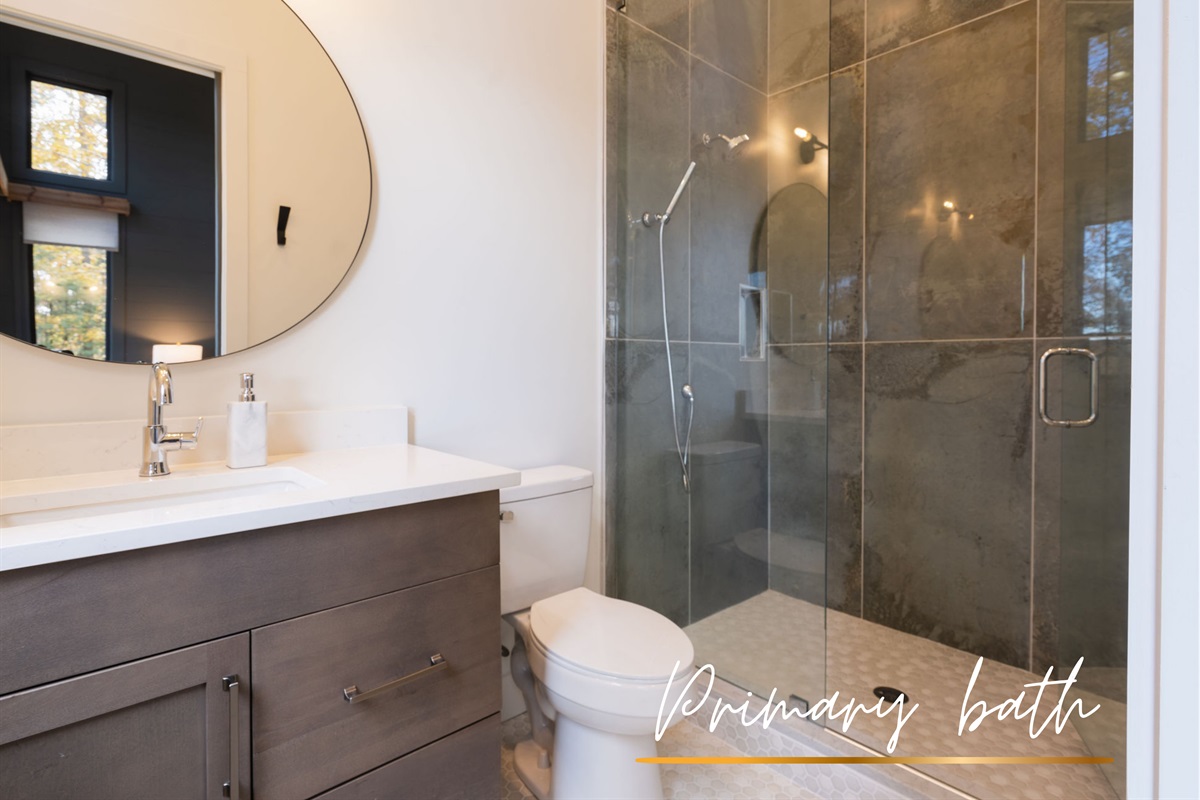 The sleek primary bathroom features a walk-in glass shower and contemporary finishes for a spa-like experience.