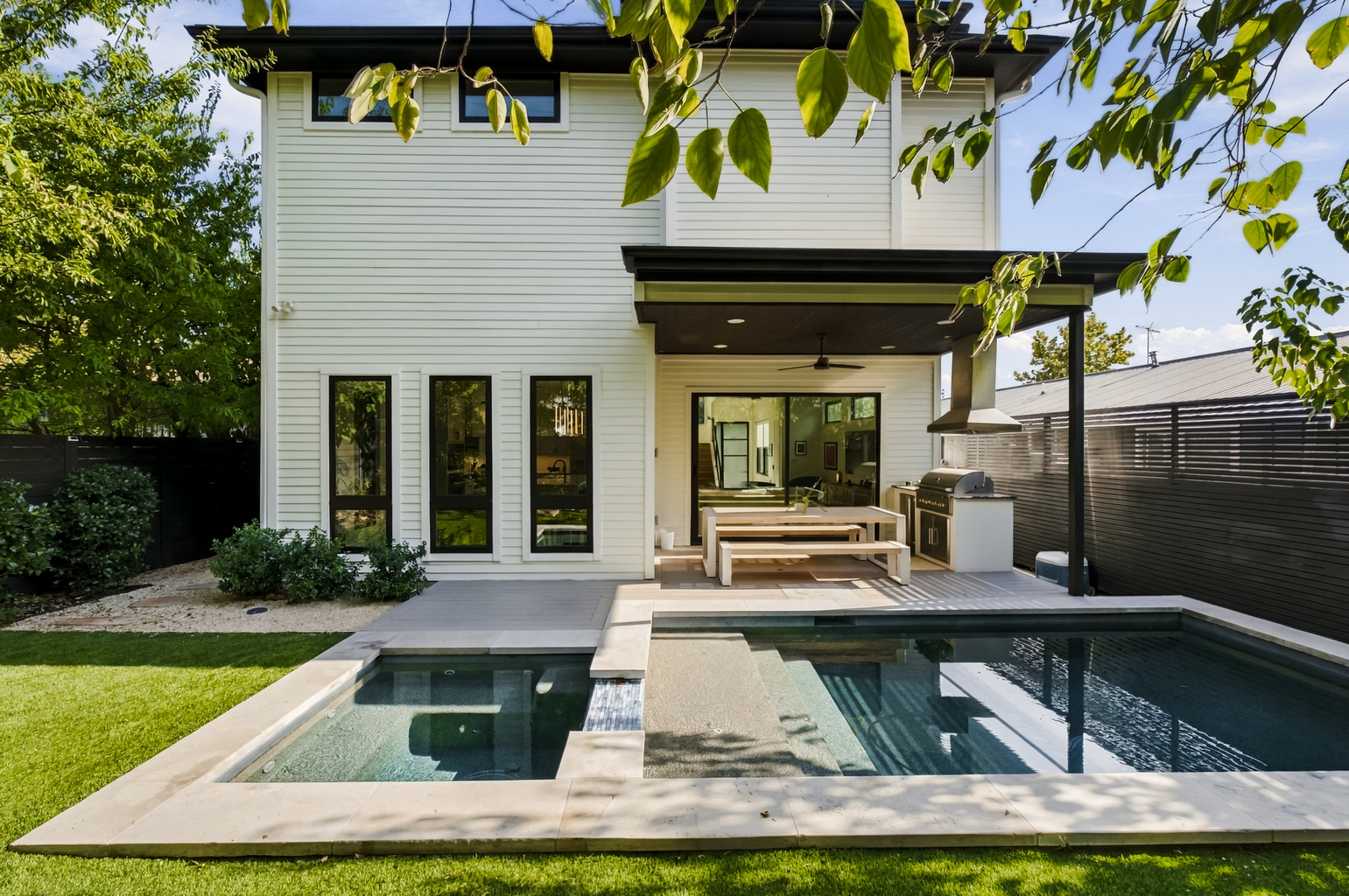 Private pool and spa framed by turf and modern outdoor living space.