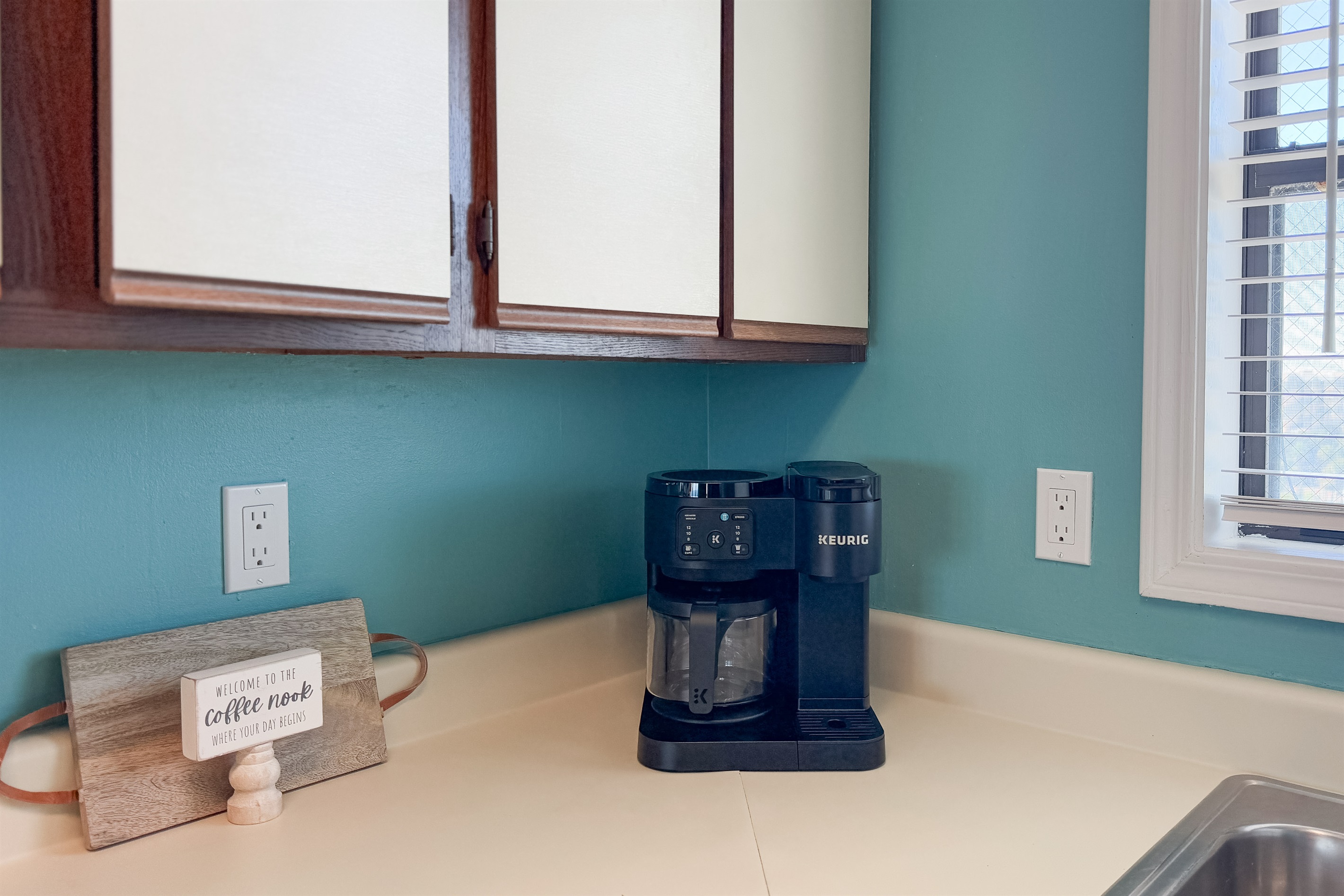 Enjoy your morning brew with both a traditional coffee pot and a single-serve machine, complemented by essential countertop appliances in this well-equipped kitchen.