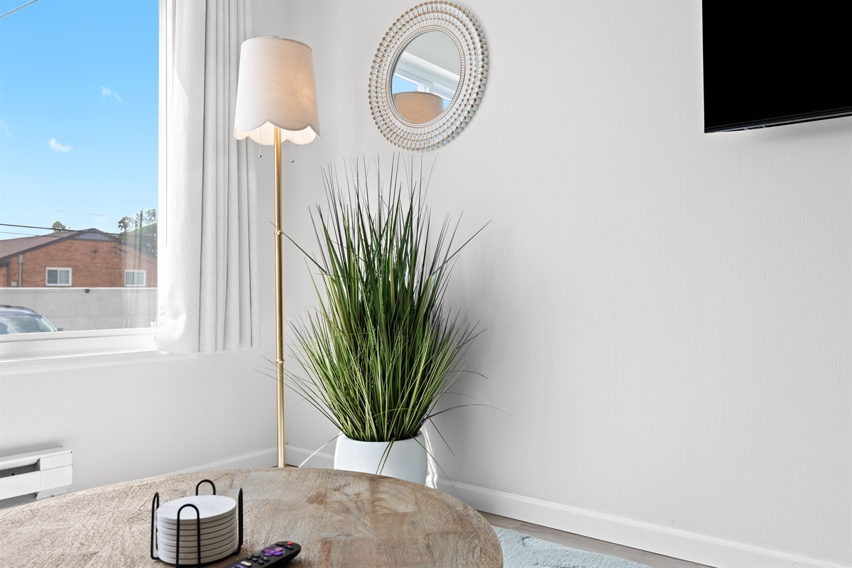 Charming corner with decorative mirror and plant for a homey feel.