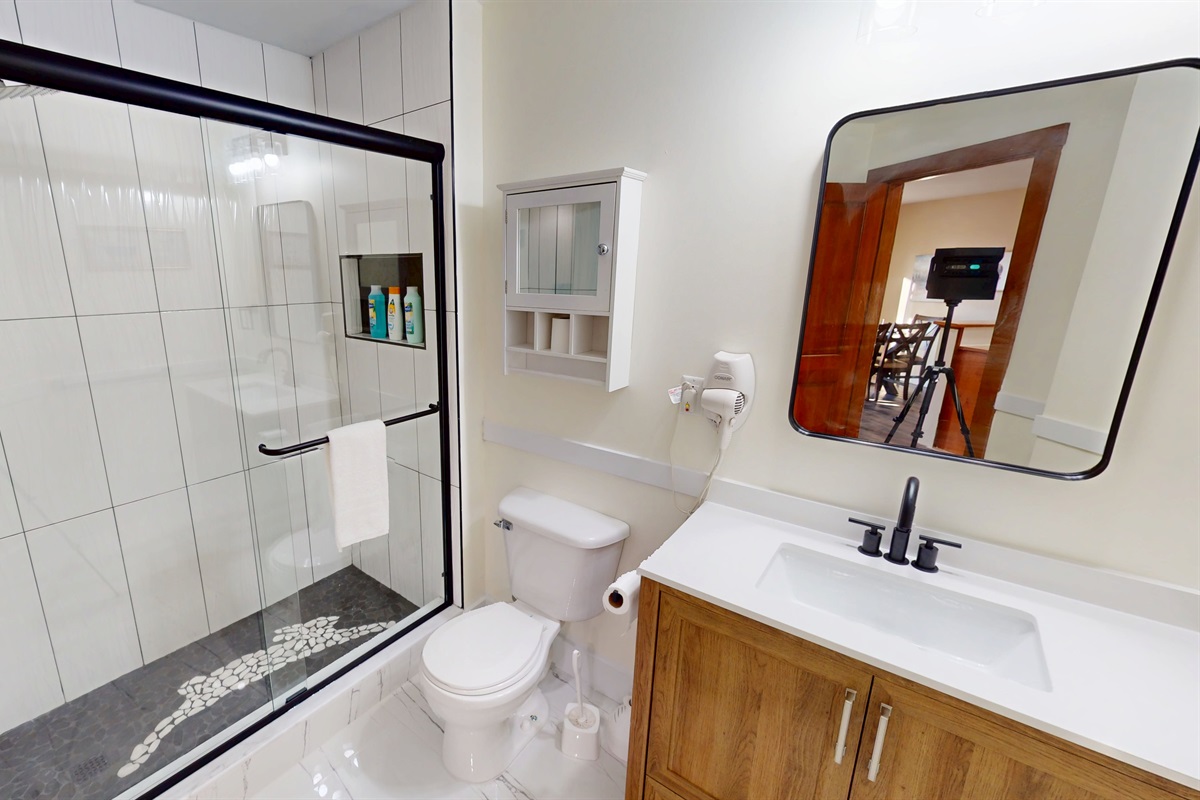 Crisp, renovated bath with glass shower and modern vanity.