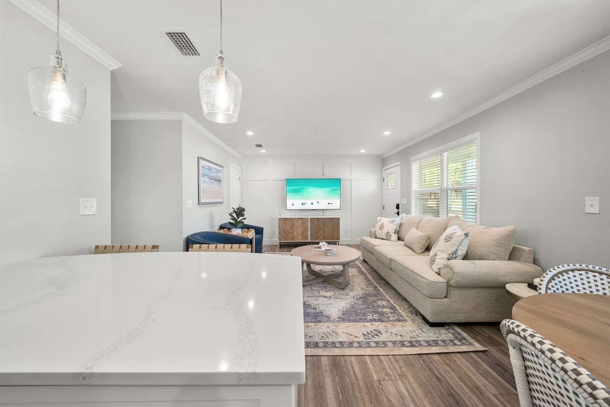 Living room of Unit A. Featuring a sleeper sofa, open concept to the kitchen and a smart TV.