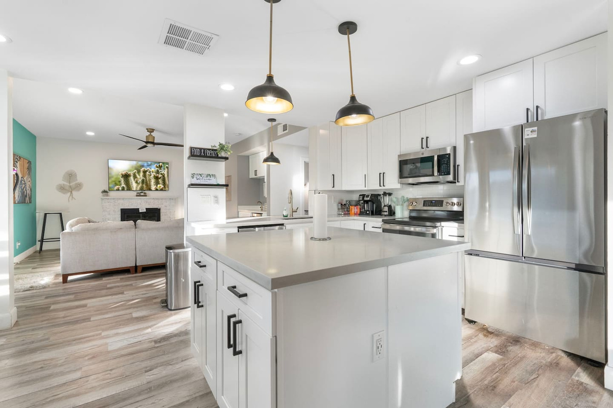 A chef's kitchen with sleek stainless finishes, open to the living space beyond.