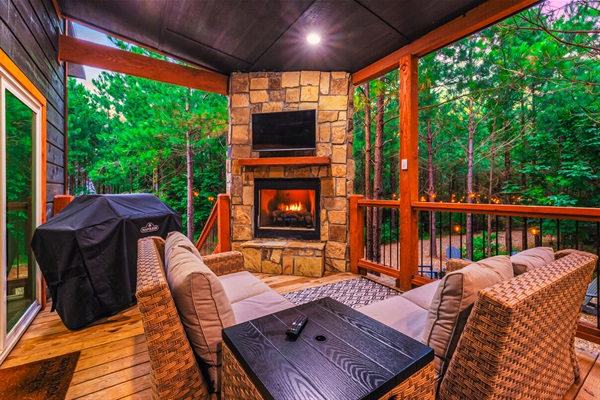 Private outdoor deck with seating area, propane grill, TV and fireplace