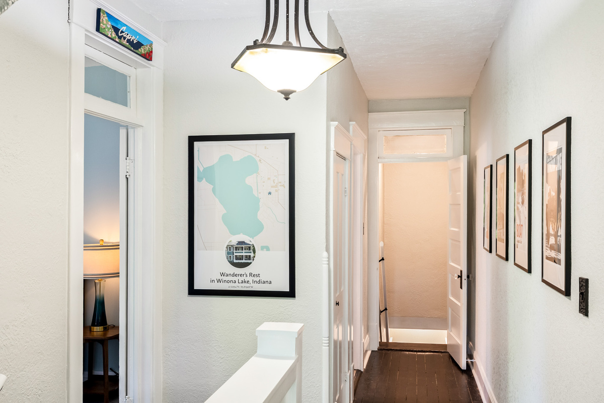 Welcome to the adventure level. The upper-floor hallway features custom local maps and vintage travel-inspired decor connecting the upper bedrooms.